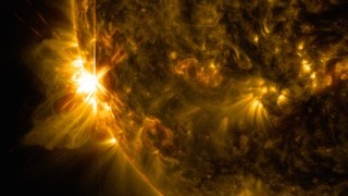 A solar flare bursts off the left limb of the sun in this image captured by NASA's Solar Dynamics Observatory on June 10, 2014, at 7:41 a.m. EDT. This is classified as an X2.2 flare, shown in a blend of two wavelengths of light: 171 and 131 angstroms, colorized in gold and red, respectively. Cropped. Image Credit: NASA/SDO/Goddard/Wiessinger