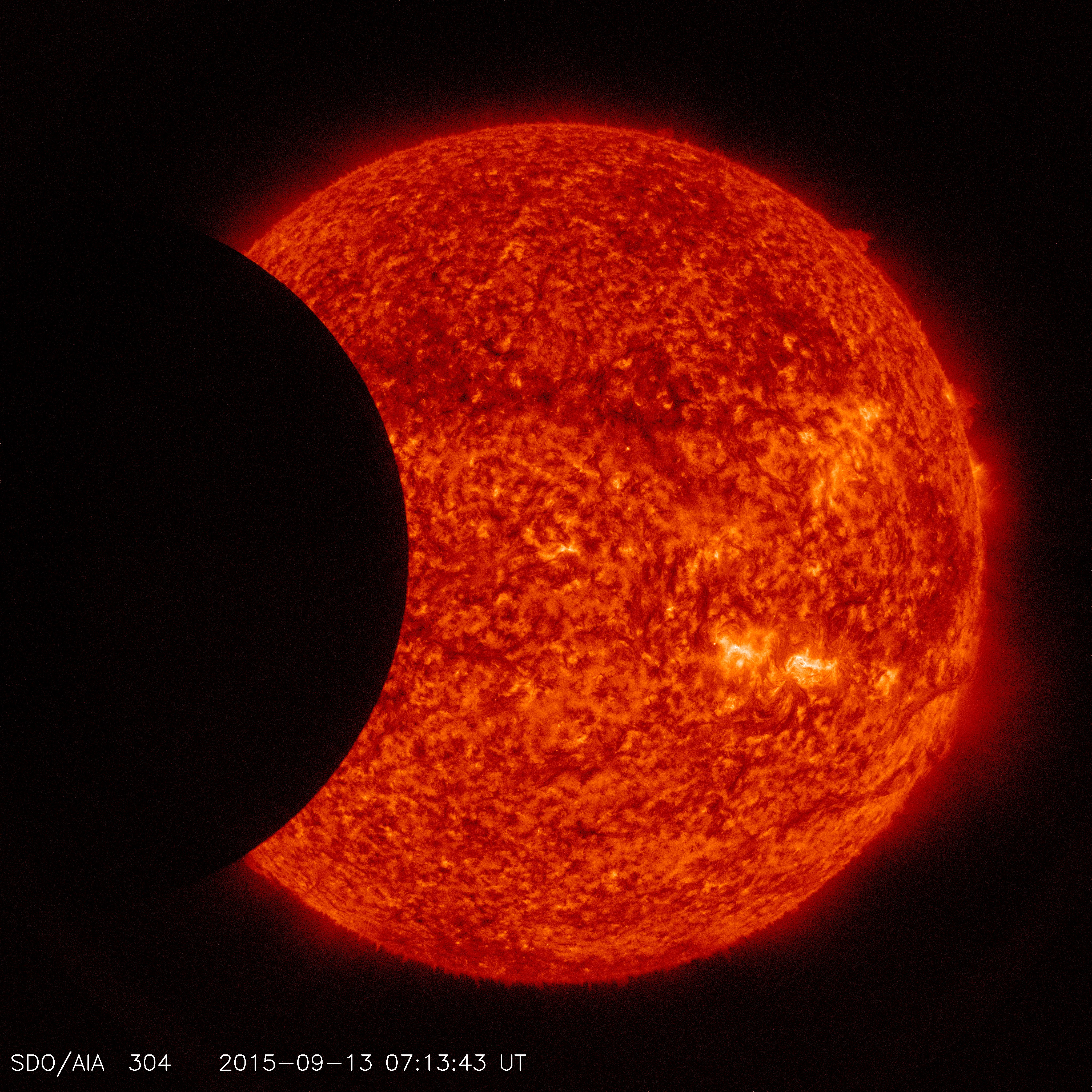 Image of the moon transiting across the sun, taken by SDO in 304 angstroms on September 13, 2015. Credit: NASA/SDO