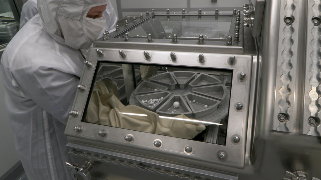 OSIRIS-REx team members practice extracting samples of asteroid Bennu from the Touch-and-Go Sample Acquisition Mechanism (TAGSAM) on June 8, 2023. Teflon spheres were used to represent material from Bennu.