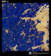 The copper color in this infrared combination is the presence of lake ice in the Northwest Territories in northern Canada. The lake on the right side is Whitefish Lake, in a region with numerous glacial landforms. Bright wrinkle-like lines are eskers, ridges made of sand and gravel formed by glacial sediments deposited by meltwater rivers flowing on the ice. The blue color is land dominated by shrub tundra with some spruce stands.