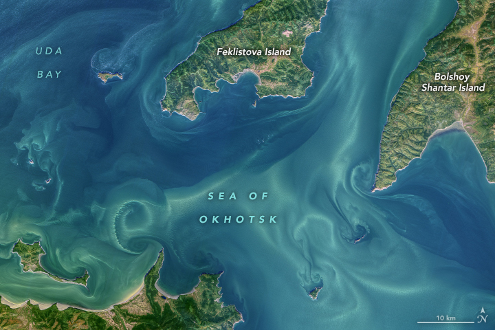 The transition from smooth, laminar flow to mixed, turbulent flow is visible in this natural-color image of tidal currents in the western Sea of Okhotsk. The image of the Shantar Islands and Uda Bay was acquired on September 24, 2021, by the Operational Land Imager (OLI) on Landsat 8.

The currents around the Shantar Islands are heavily influenced by the strong tides and by freshwater discharge from rivers draining into Uda Bay. The waters here are frozen for much of the year. When the sea ice melts and freshwater snowmelt swells the Uda River, plumes of low-salinity water can reach far offshore.