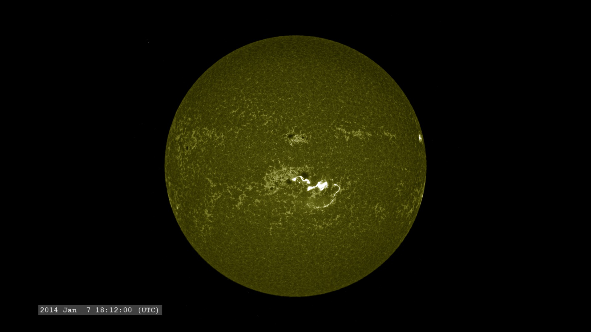 At the ultraviolet wavelength of 160 nm, we see an image which still resembles the view in visible light, but with the faculae surrounding the sunspots more visible.  The flare appears like a bright arc from the regions.