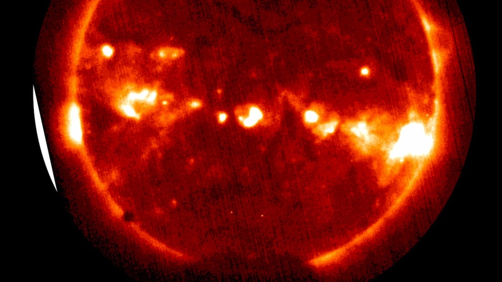 Venus appears as a black dot on the lower left edge of the sun in this GOES satellite image, captured during the 2004 transit. 