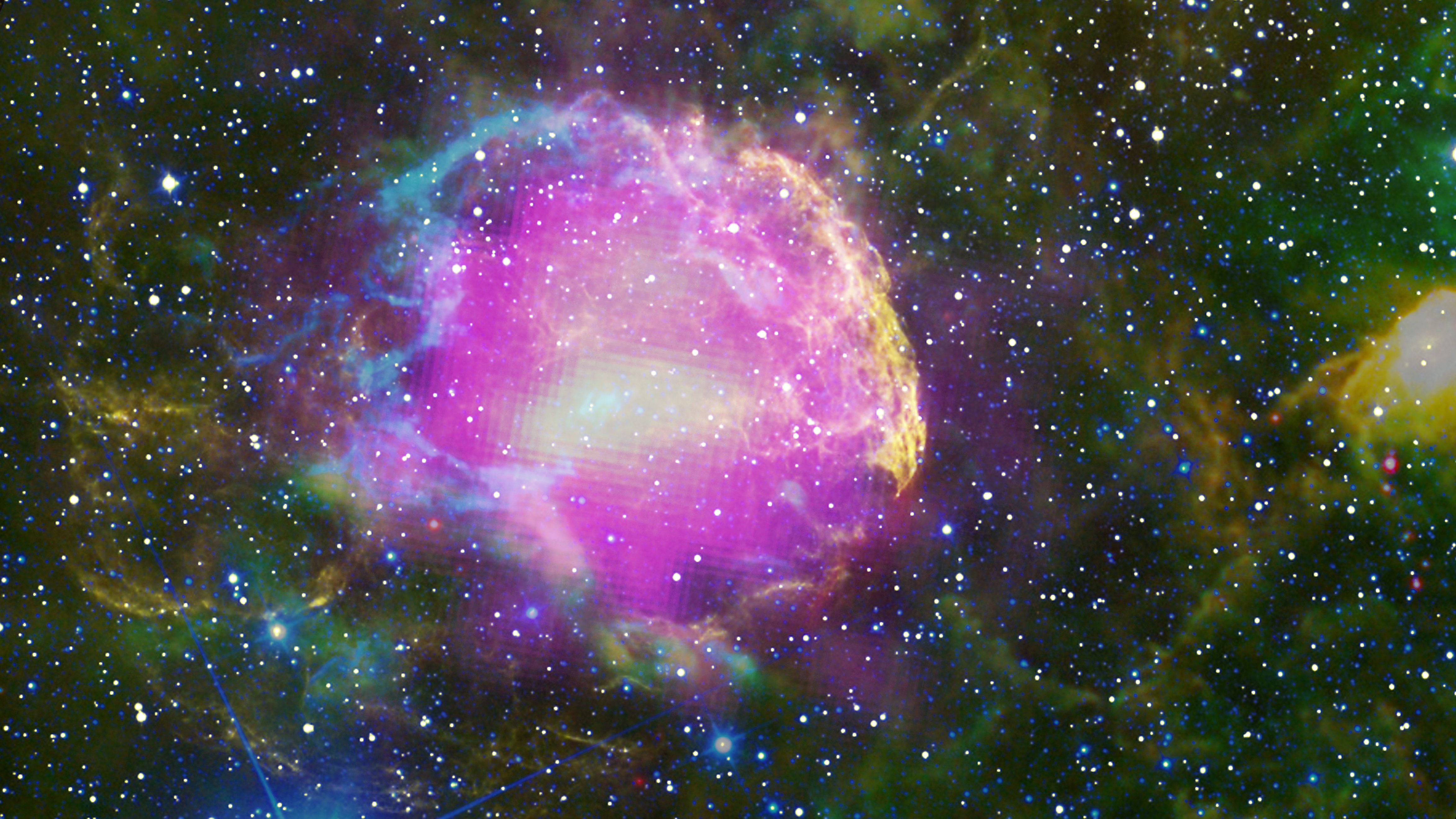 This multiwavelength composite shows the supernova remnant IC 443, also known as the Jellyfish Nebula. Fermi GeV gamma-ray emission is shown in magenta, optical wavelengths as yellow, and infrared data from NASA's Wide-field Infrared Survey Explorer (WISE) mission is shown as blue (3.4 microns), cyan (4.6 microns), green (12 microns) and red (22 microns). Cyan loops indicate where the remnant is interacting with a dense cloud of interstellar gas.Credit: NASA/DOE/Fermi LAT Collaboration, Tom Bash and John Fox/Adam Block/NOAO/AURA/NSF, JPL-Caltech/UCLA