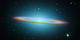 The turquoise glow in this composite image made from visible light and infrared observations shows the circular shape of M104’s elliptical.