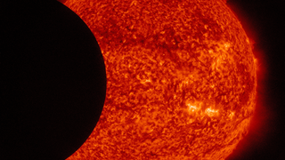 Image of the moon transiting across the sun, taken by SDO in 304 angstroms on September 13, 2015.  Credit: NASA/SDO