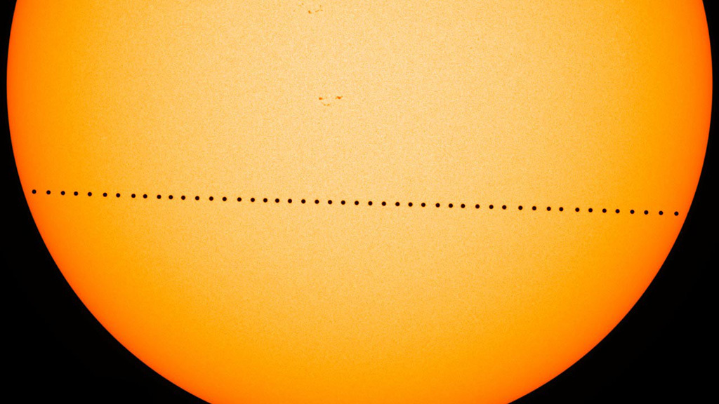 Mercury appears as a black dot while crossing the face of the sun during a rare transit.