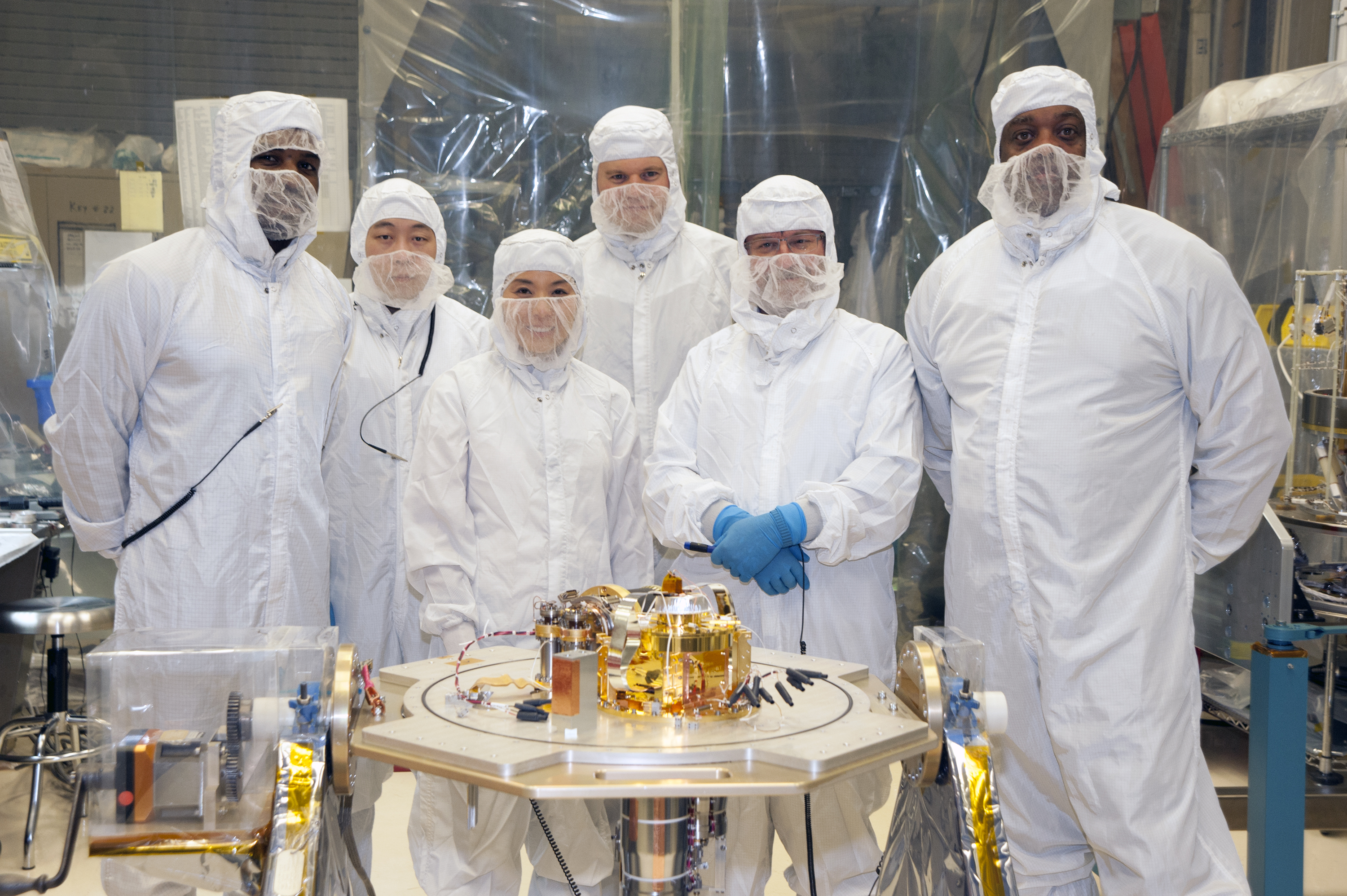 XRISM team members pose with the XRISM Calorimeter Spectrometer Insert in a NASA Goddard clean room. From left to right, they are Bryan James, Mike Sampson, Tomomi Watanabe, Pete Barfknecht, Scott Porter, and Sinclair Douglas.Credit: Larry Gilbert/NASA
