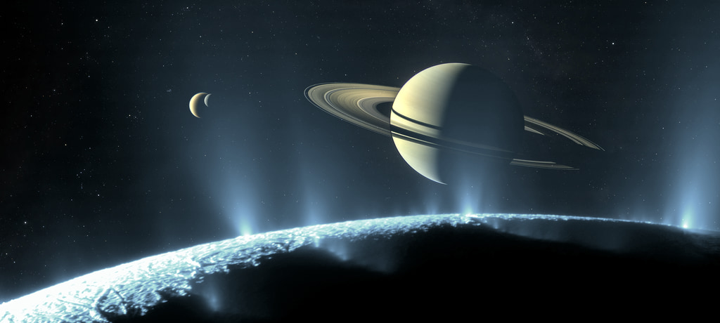 Artist’s concept of Saturn and its icy moons Enceladus (foreground), Titan (large crescent at upper left), and Rhea (small crescent). Based on imagery from the Cassini spacecraft.