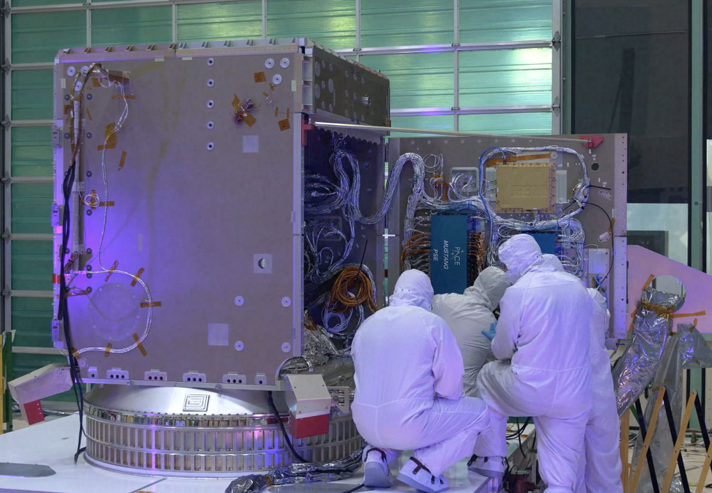 Beauty shots of the PACE spacecraft in the cleanroom with engineers.