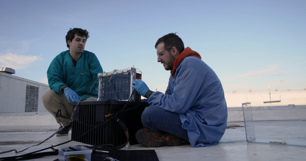 This video shows engineers conducting an open-sky test of the BurstCube satellite’s GPS at NASA’s Goddard Space Flight Center in Greenbelt, Maryland. The first shot shows Benjamin Nold (NASA) and Justin Clavette (SSAI) sitting around the spacecraft on a rooftop while Kate Gasaway (NASA) works in the background. The second shot shows Gasaway and Clavette looking at a laptop in the background, with BurstCube in the foreground. The third shot shows birds landing on an antenna on the rooftop. The fourth shot shows Clavette and Nold crouched next to the BurstCube satellite. The fifth shot shows Gasaway typing on the laptop. The sixth shot is a closer view of Gasaway and Clavette looking at the laptop. The eighth shot shows some of the electronics used to monitor the spacecraft. The ninth shot shows the data readout from the spacecraft on the laptop. The final shots show birds flying over the rooftop.  

Credit: NASA/Sophia Roberts