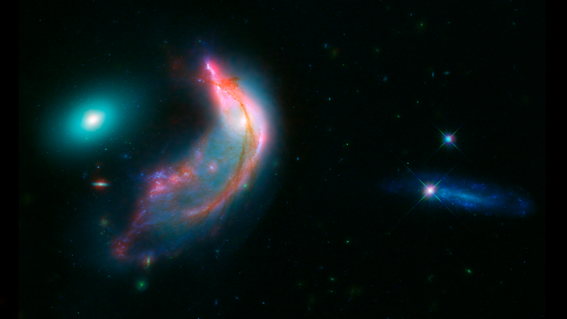 The Penguin and the Egg Collectively known as Arp 142, this cosmic penguin is actually a galaxy called NGC 2936 that has been twisted by the gravitational pull of another galaxy, called NGC 2937. Over time, gravity is slowly pulling the pair together and they will eventually merge. Data from NASA's Spitzer and Hubble space telescopes have been combined to show these dramatic galaxies in light that spans the visible and infrared parts of the spectrum. For more information: Arp 142: The Penguin and the Egg  Download the desktop version here.Download the smartphone version here.Credit: NASA-ESA/STScI/AURA/JPL-CaltechAlt text: Two glowing, colorful galaxies look like a penguin and its egg and are shown here in infrared from the retired Spitzer Space Telescope and visible light from the Hubble Space Telescope.Image description (desktop wallpaper): A penguin-shaped arc of bright dust and gas that includes bright streaks and spots of pink, orange, and purple sits on the left side of a black backdrop speckled by small, bright, green, and blue stars. Just above this is a bright white oval resembling an egg and surrounded by glowing turquoise. Two bright stars marked by X-shaped spikes of light lay across a bright blue swath at the right of the image.