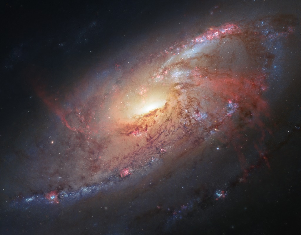 An image of the spiral galaxy M106 created through a comibination of Hubble data and ground-based images