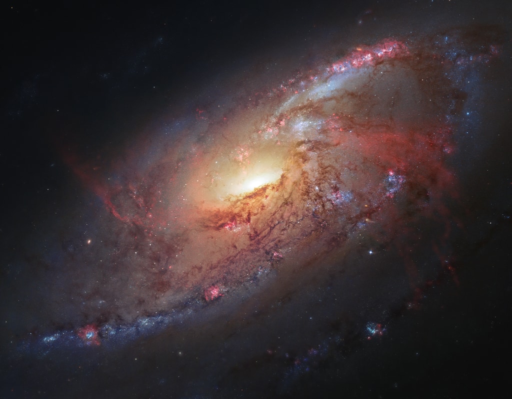 This composite image of galaxy M106 focuses on its active center, where large amounts of gas are thought to be falling into and fueling a supermassive black hole.